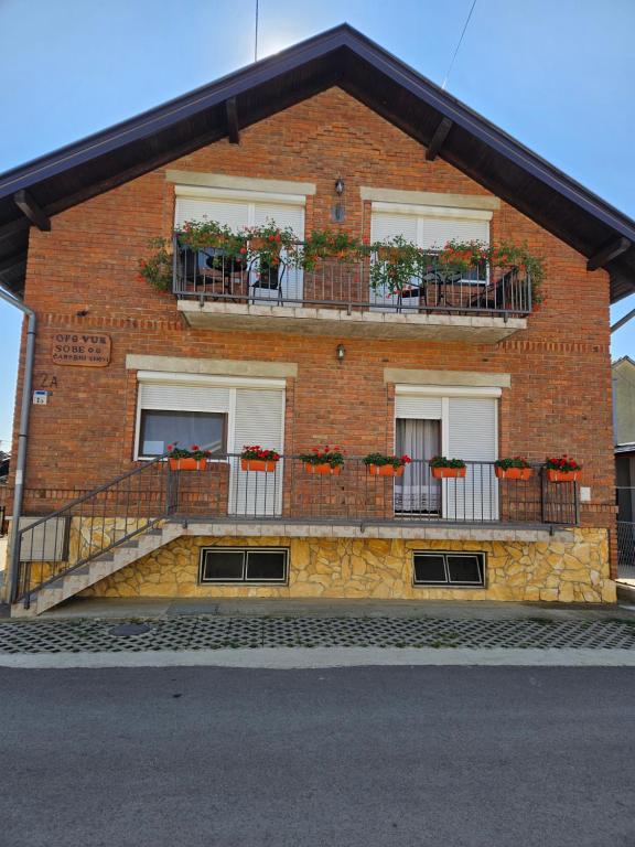 a brick building with flower boxes on the balconies at OPG Vuk Sobe bed&breakfast "Čarobni snovi" in Darda