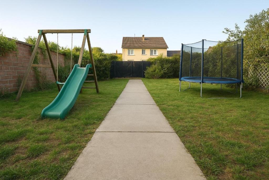 a playground with two swings in a yard at Maison F2 grand jardin Grand Est Paris in Gagny