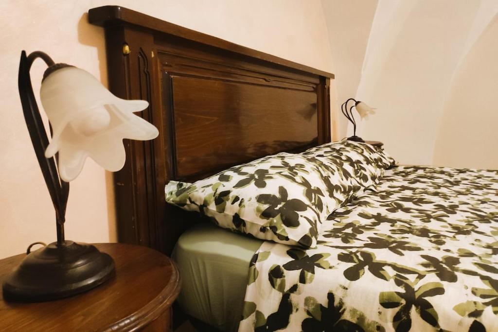 een slaapkamer met een bed en een lamp op een tafel bij Casa vacanza Gallipoli centro in Gallipoli