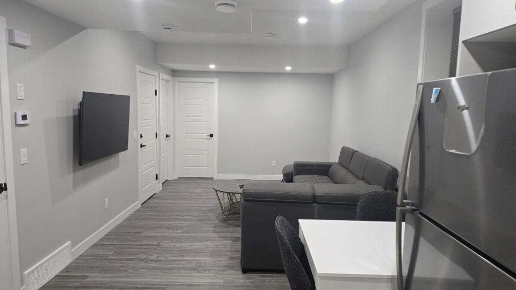 a living room with a couch and a tv at Royaldee Cozy Home 2beds & 2baths in Calgary