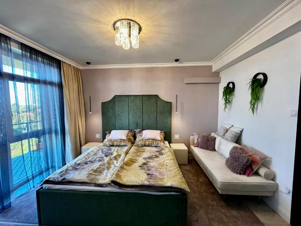 a bedroom with a large bed and a couch at Violet Suite in Nyíregyháza