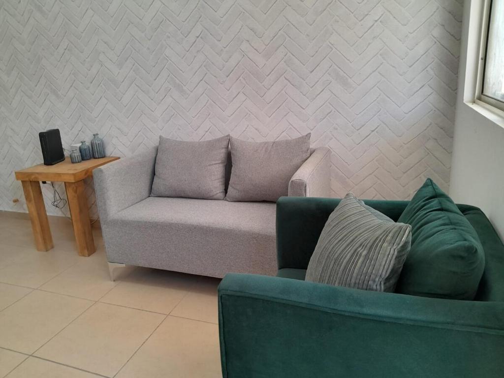 een woonkamer met een groene bank en een tafel bij Casa para toda la familia o amigos Zona Industrial Monterrey in Monterrey
