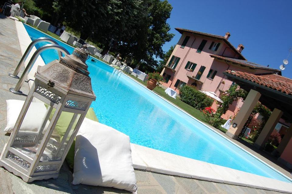 a large swimming pool with a lantern next to a building at Torre dei Frati Bed & Breakfast in Fossano