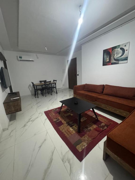 a living room with a couch and a table at Jawharet karam in El Aouina Station