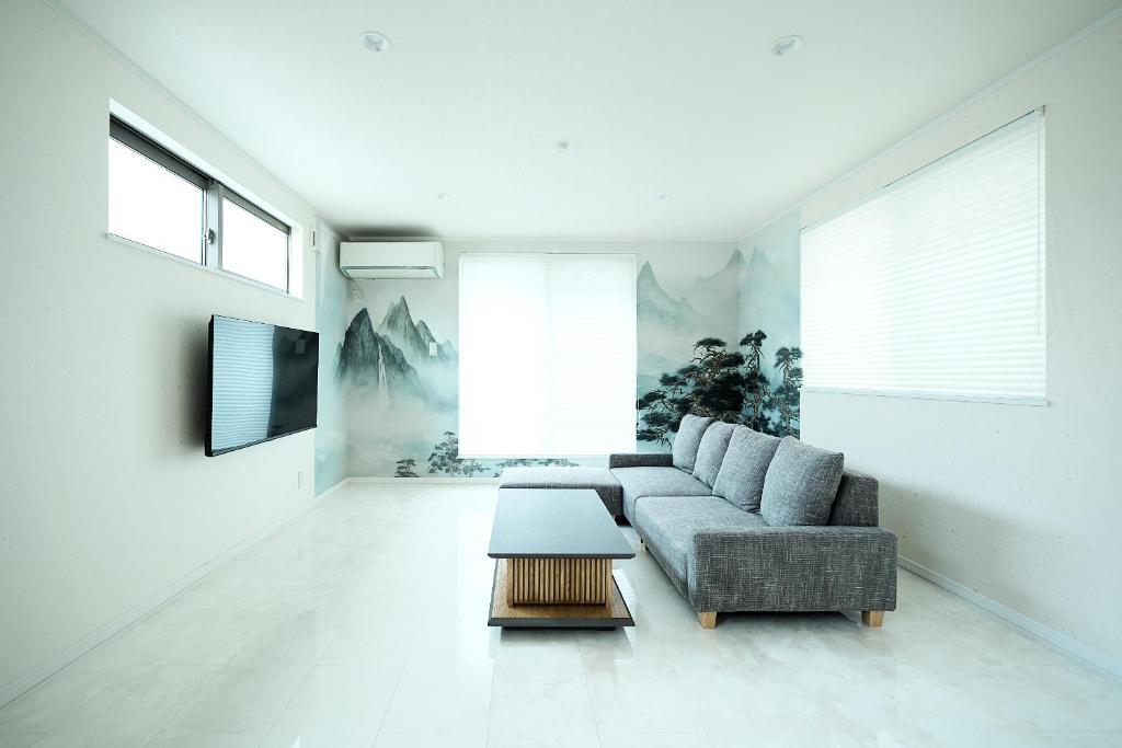 東京にあるWANOYADO Tokyo - Modern Japanese House near Shinjuku & Shibuyaのソファとテーブルのあるリビングルーム
