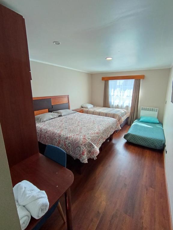 a room with two beds and a wooden floor at Visok B&B in Frutillar
