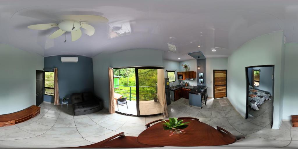 マヌエル・アントニオにあるKalegio Lodge Full Furnished Apartmentsの大きなリビングルーム(シーリングファン、テーブル付)