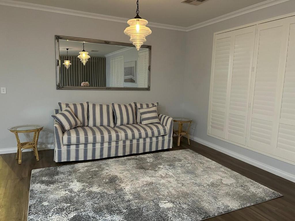 a living room with a couch and a mirror at Luxury Hamptons Beach House in Kinross