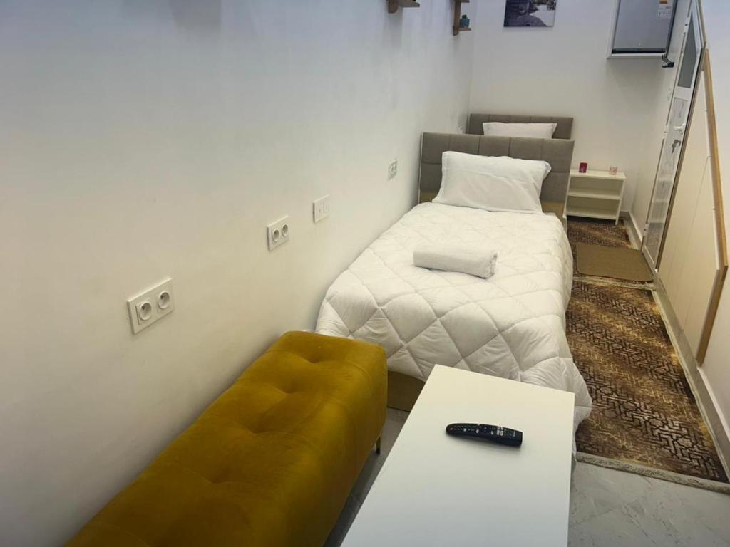 Habitación pequeña con cama y banco en Studio cozy 04, en Tánger