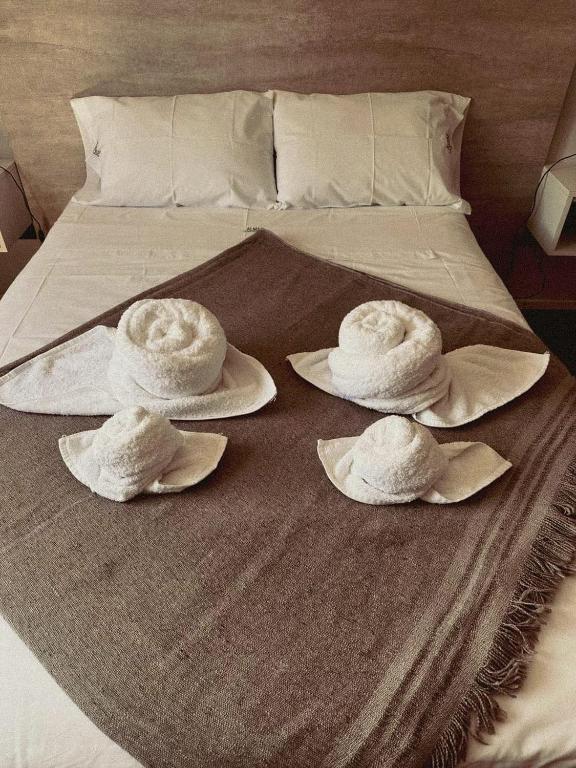 a bed with three hats on top of it at ALMAS CASAS de SIERRAS in San Lorenzo