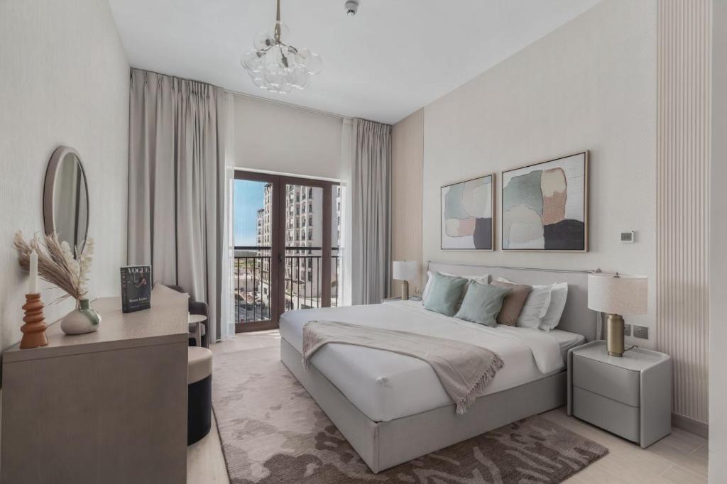 a white bedroom with a large bed and a window at F1 Yas Luxury 1BR Golf&Water View w tkt discount in Abu Dhabi