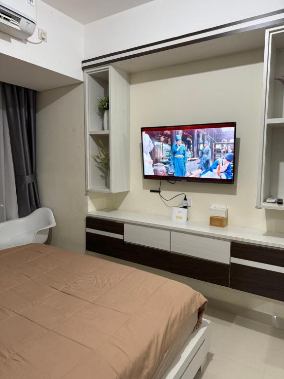 Una habitación con una cama y un televisor en la pared. en Pollux Superior 2 seaview by Superstay, en Batam Centre