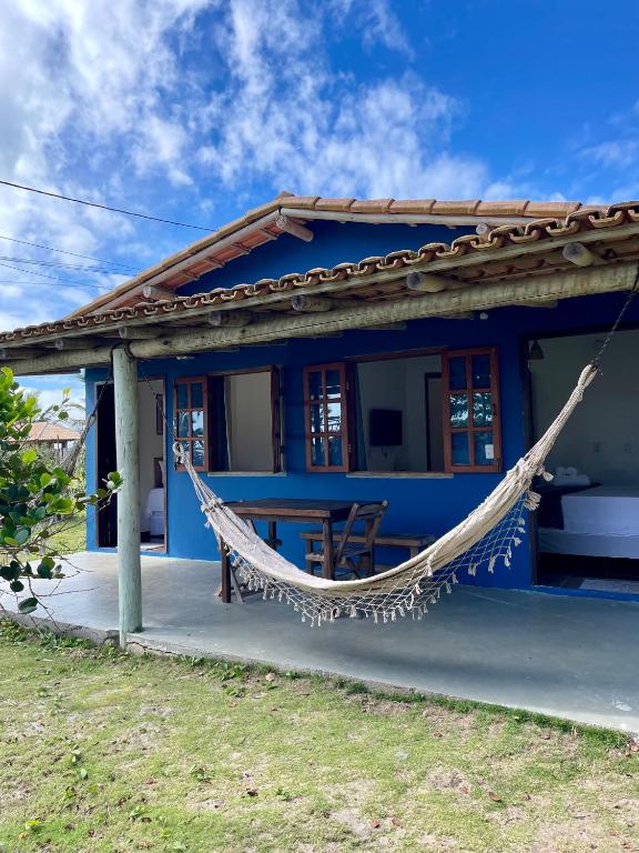 a blue house with a hammock in front of it at Casa Sol e mar in Porto Seguro