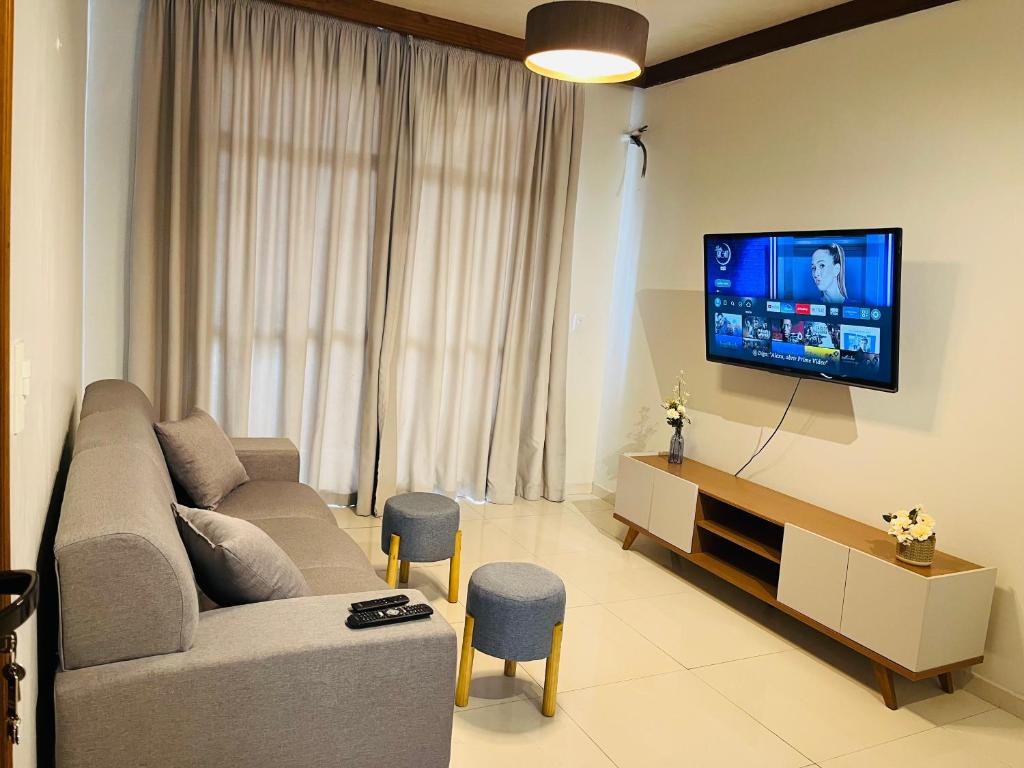 a living room with a couch and a flat screen tv at Jardim das Pérolas 101 in Belém