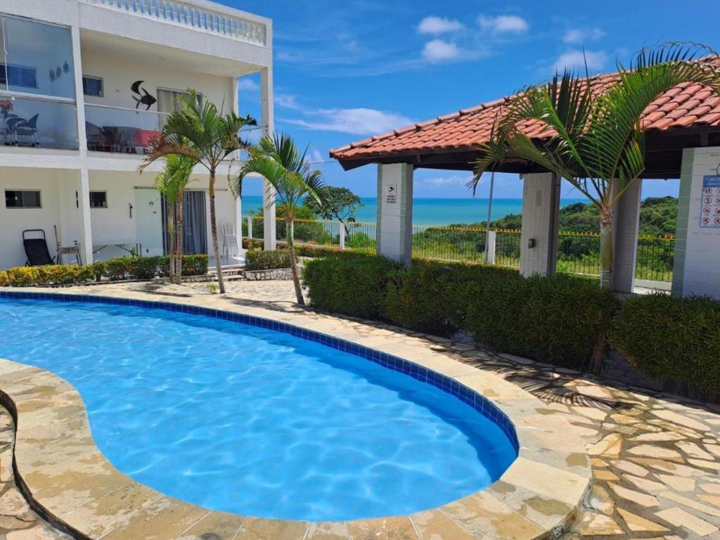 a swimming pool in front of a building at Flat Mar doce lar in Conde