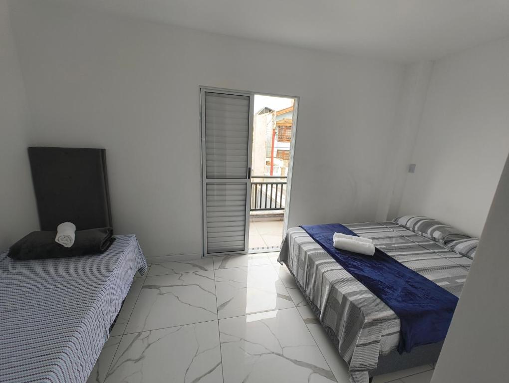 a bedroom with two beds and a television in it at Feiras e Compras 4 in Sao Paulo