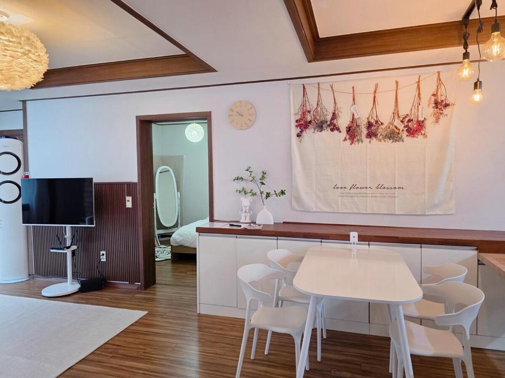 Kwangan-dongにあるDaeyeon Stay Yeonのテーブルと椅子とテレビのある部屋
