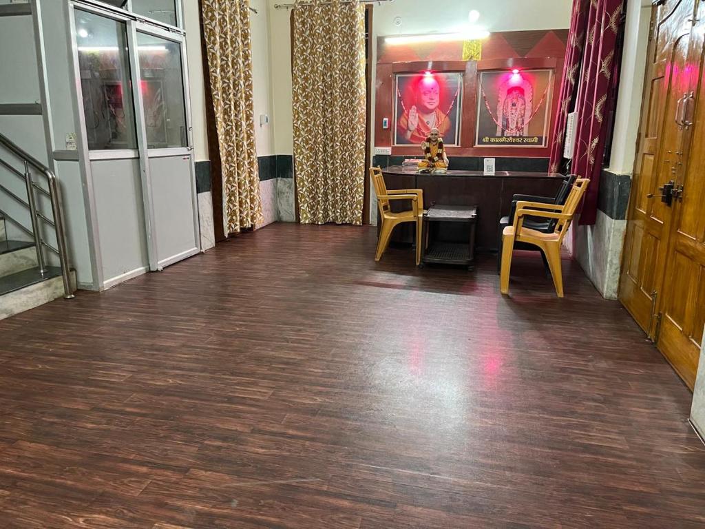 a dining room with a table and yellow chairs at Adichunchangiri Mahasamsthana Math in Naimishāranya