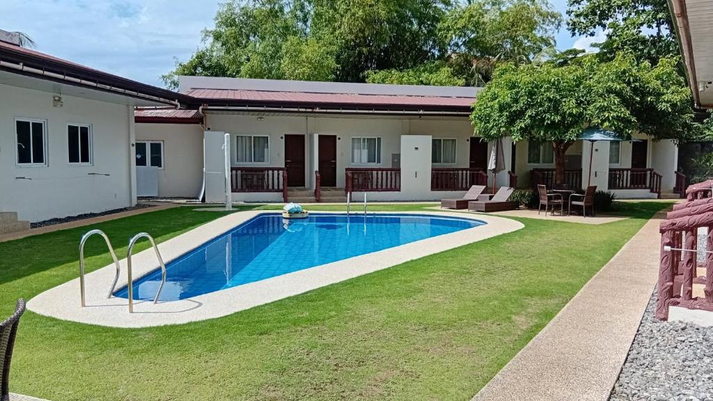 a swimming pool in a yard next to a house at Freedive Panglao Resort in Panglao Island