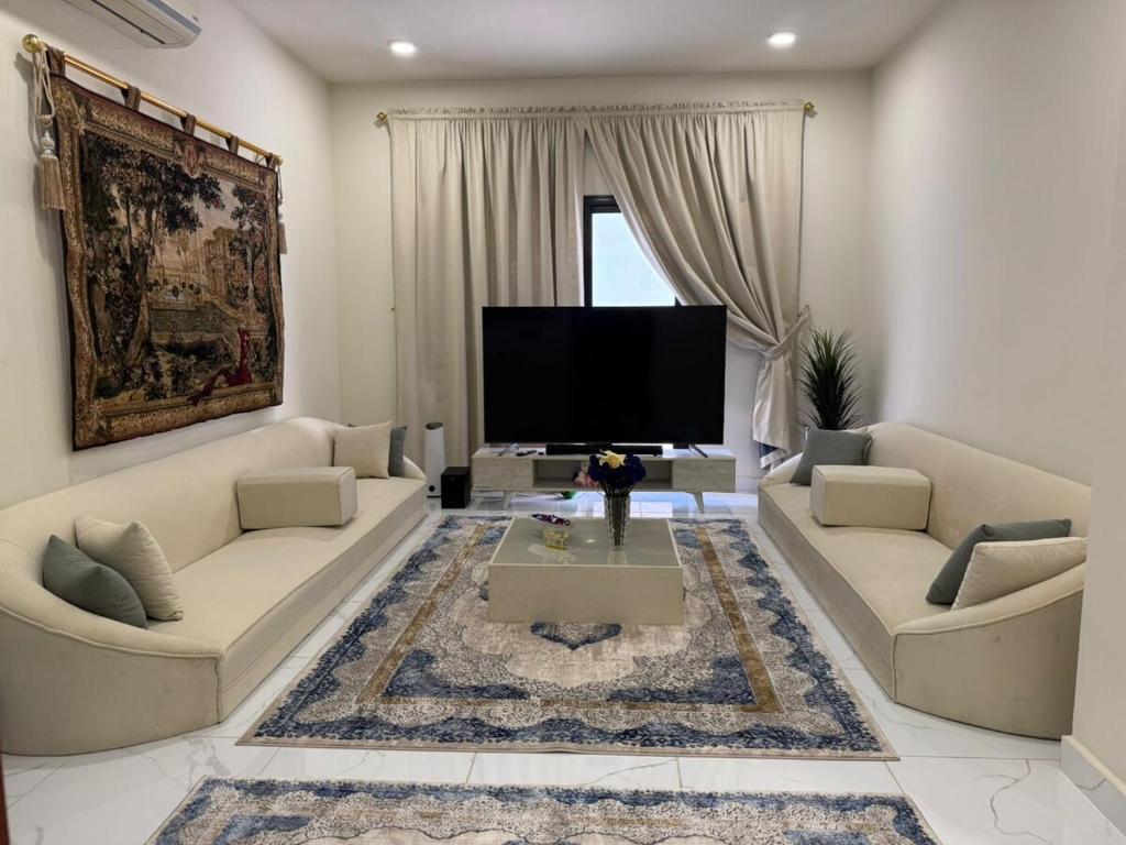 a living room with two couches and a flat screen tv at Hamad in Al Fayşalīyah