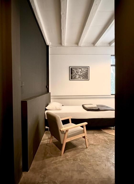 a bedroom with a bed and a chair in it at Chatel Samyan - Self check-in in Bang Rak