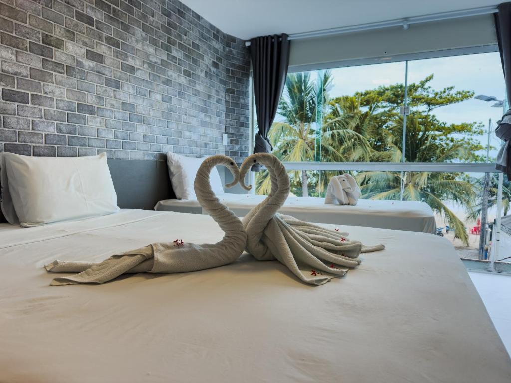 two metal swans making a heart on a bed at Pousada da Orla in Maragogi
