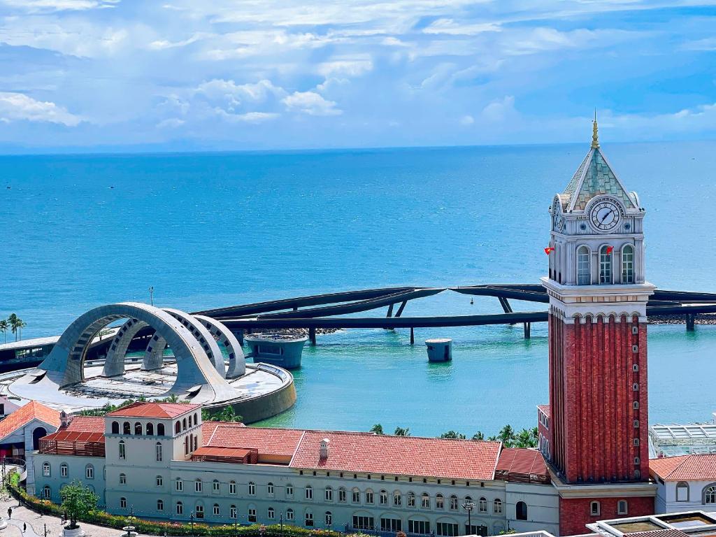 ein Gebäude mit einem Uhrturm am Meer in der Unterkunft Hayha Apartment by Haus Hospitality in Phu Quoc