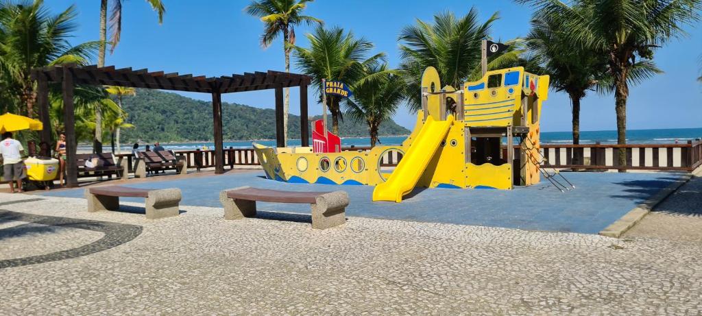 a playground with a yellow slide on the beach at Encontro marcado in Praia Grande