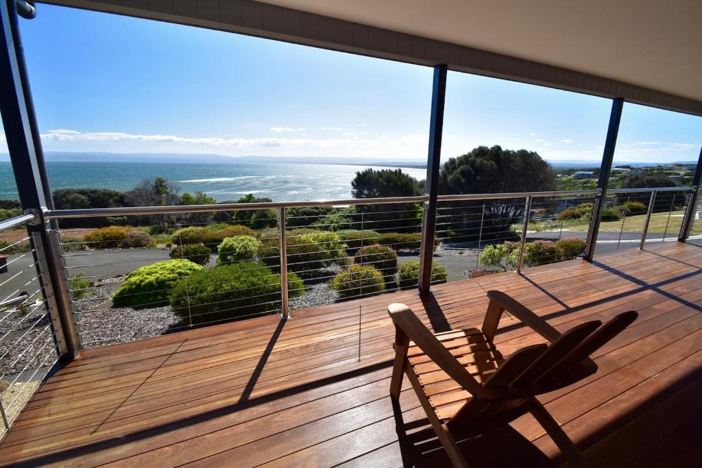 een balkon met twee stoelen en uitzicht op de oceaan bij Tranquility at Freycinet in Coles Bay