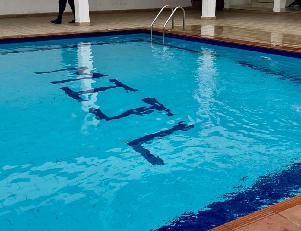 un grupo de personas nadando en una piscina en Luxury Penthouse with Private Rooftop Lounge & City View - Lekki Home Fairy, en Lekki