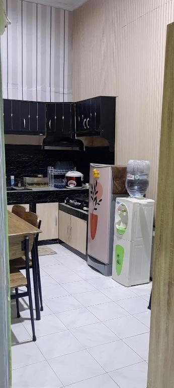 CipernaにあるHomestay Permata Cirebonのキッチン(冷蔵庫、テーブル付)