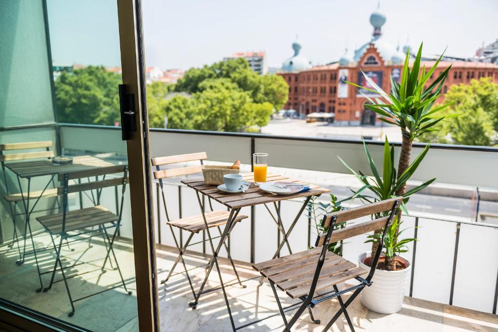 uma mesa e cadeiras numa varanda com vista em República Bed & Breakfast em Lisboa