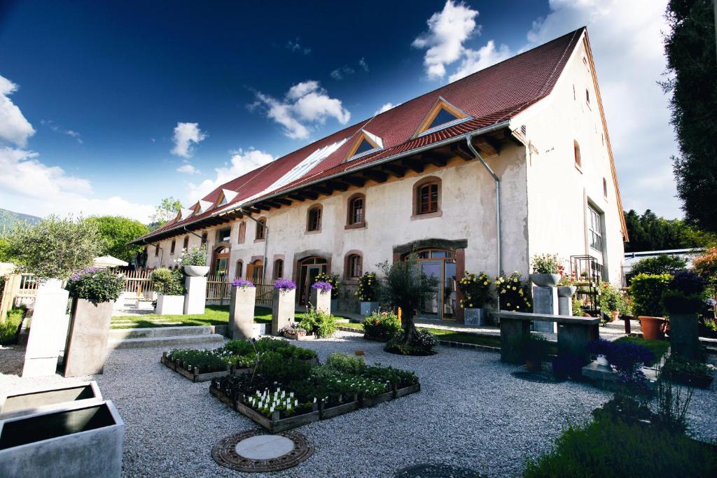 a building with a garden in front of it at hotel rainhof scheune & naturpark restaurant (Kirchzarten) in Kirchzarten