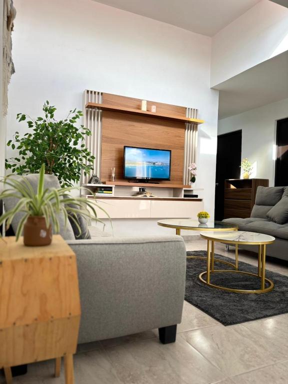 a living room with a couch and a tv at La Casa del Café - Mesa de Juegos y Comfort in Comitán
