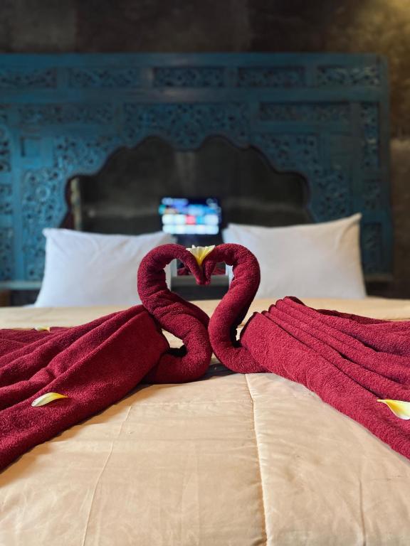 two towels in the shape of a heart on a bed at Penginapan Gelar in Jembrana