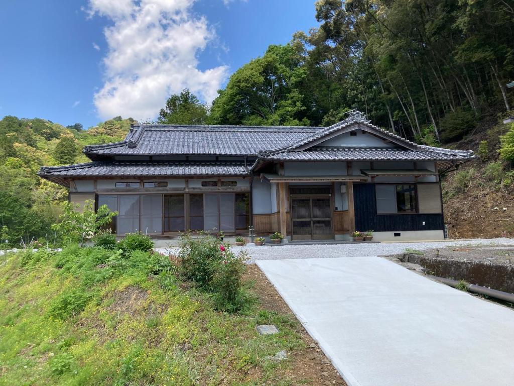 a small house with a pathway in front of it at 民泊絹家 in Izume
