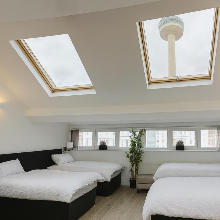 a room with four beds with windows and a tower at Beacon Apart-hotel in Liverpool