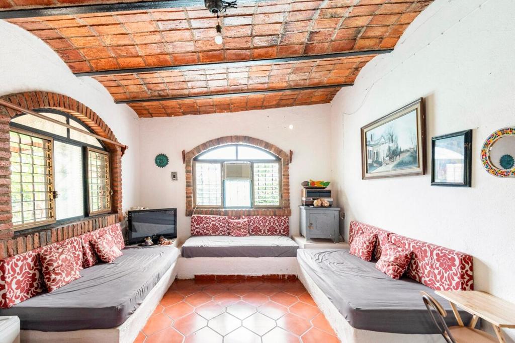 a living room with couches and a wooden ceiling at Beautiful Beach House in Lo De Marcos, Nayarit! in Lo de Marcos