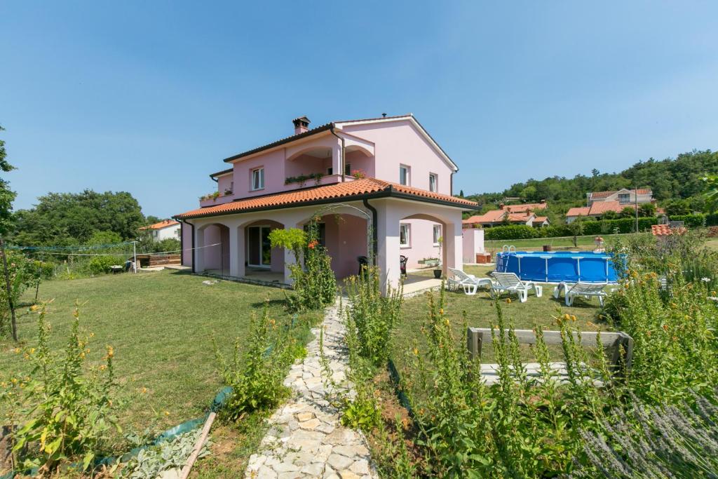 a pink house in the middle of a yard at Apartment Elina in Labin
