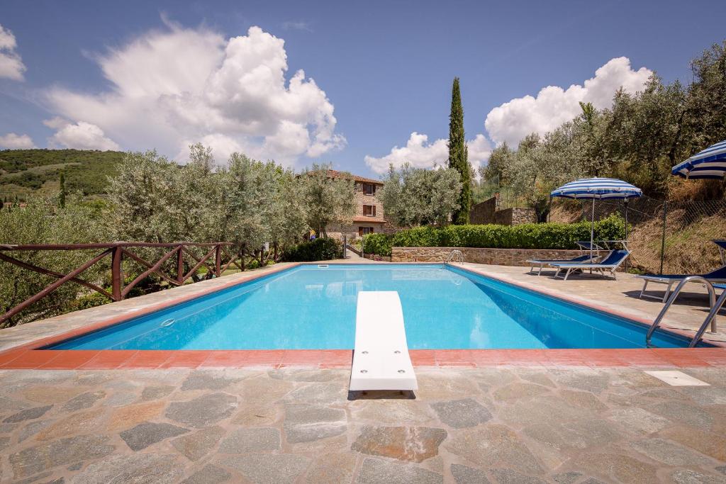 a swimming pool in front of a house at Agriturismo Le Capanne in Castiglion Fiorentino