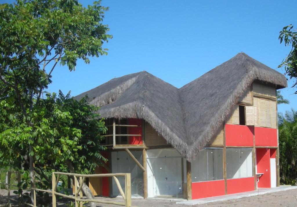 ein Haus mit einem Strohdach in der Unterkunft Bed & Breakfast Casa Dos Cajueiros in Barra Grande