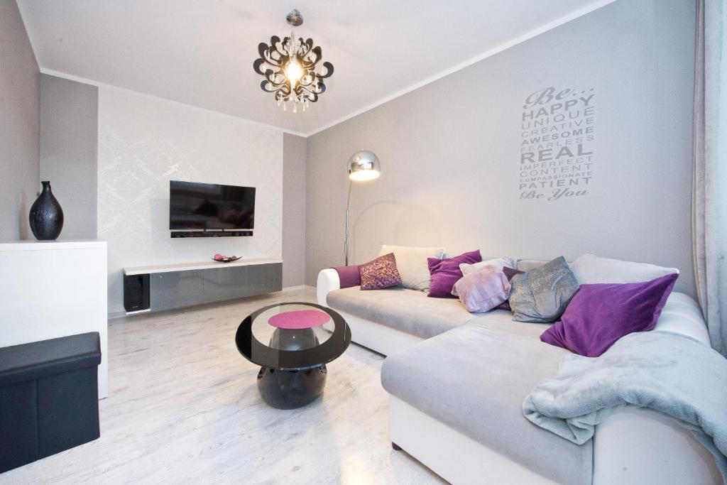 a living room with a couch and a table at YOURAPART Gdansk Morena in Gdańsk