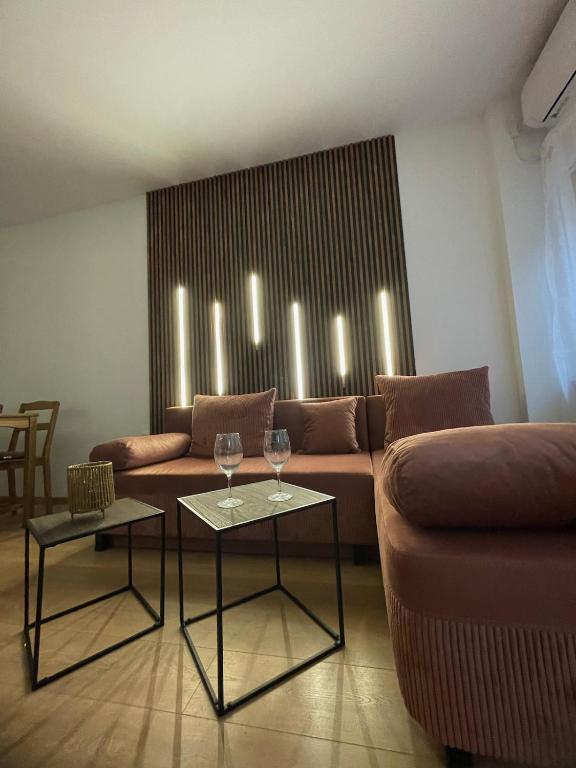 a living room with a couch and two tables with wine glasses at Atila Apartment Ruse in Ruse