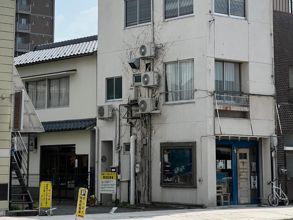 un edificio blanco con altavoces a un lado en めくる, en Matsumoto