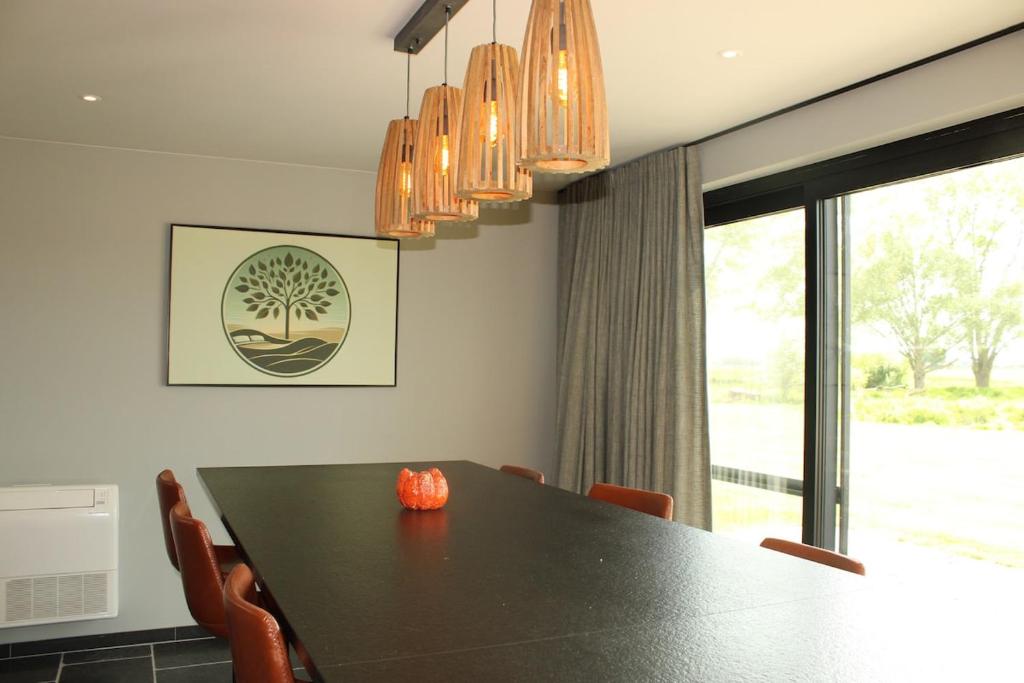a dining room with a black table and chairs at Green Bliss in Wervik