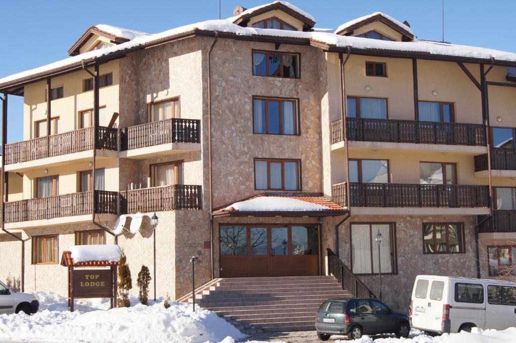 ein großes Apartmenthaus mit Schnee davor in der Unterkunft Top Lodge Apartments in Bansko