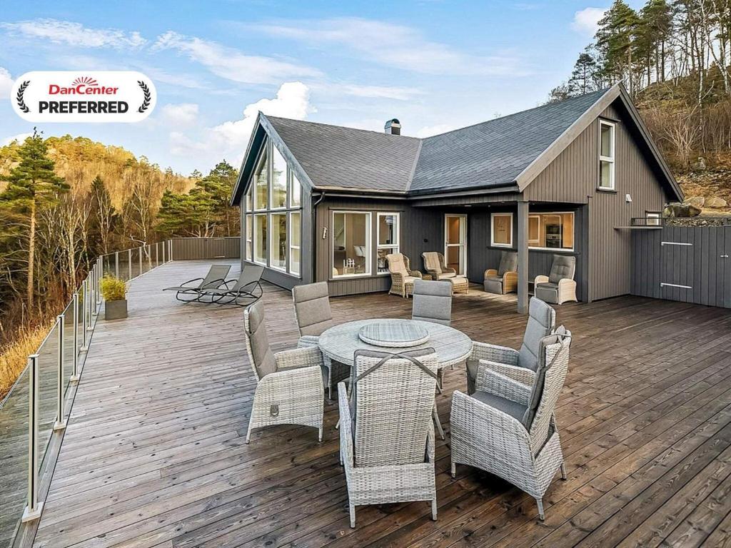 a patio with a table and chairs on a wooden deck at 8 person holiday home in lyngdal-By Traum in Lyngdal