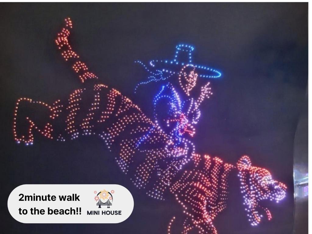 Kwangan-dongにあるMINI HOUSE Gwangan Beach #closest to the beach #drone show #cozyの帽子をかぶった男性が描かれたクリスマスの電飾看板