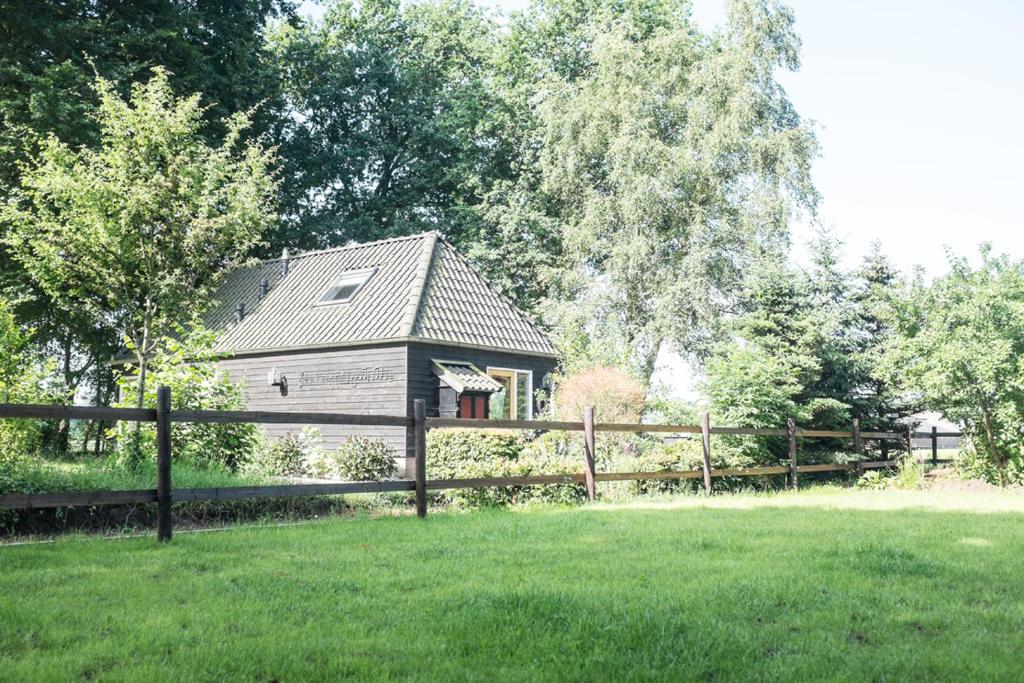 a wooden fence in front of a house at Gastenverblijf Het Muzehuis in Dalfsen