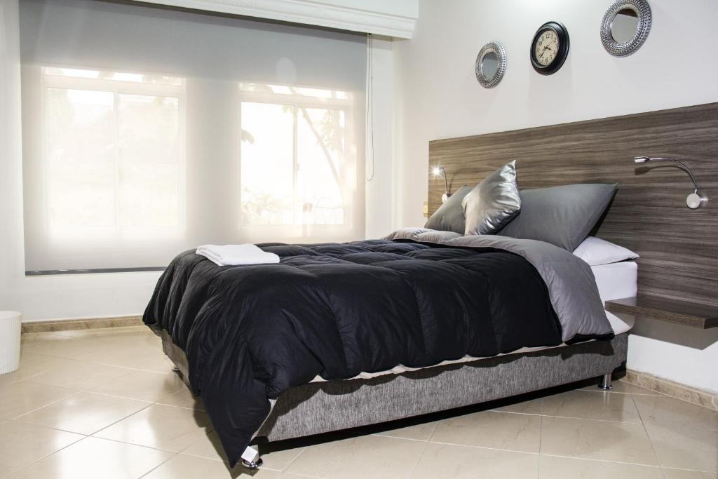 HOTEL Premium House في فلوريدا بلانكا: غرفة نوم مع سرير أسود كبير مع نافذة كبيرة